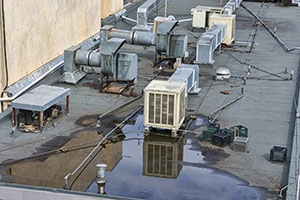 Pooling water around air conditioning systems on roof of a commercial building.